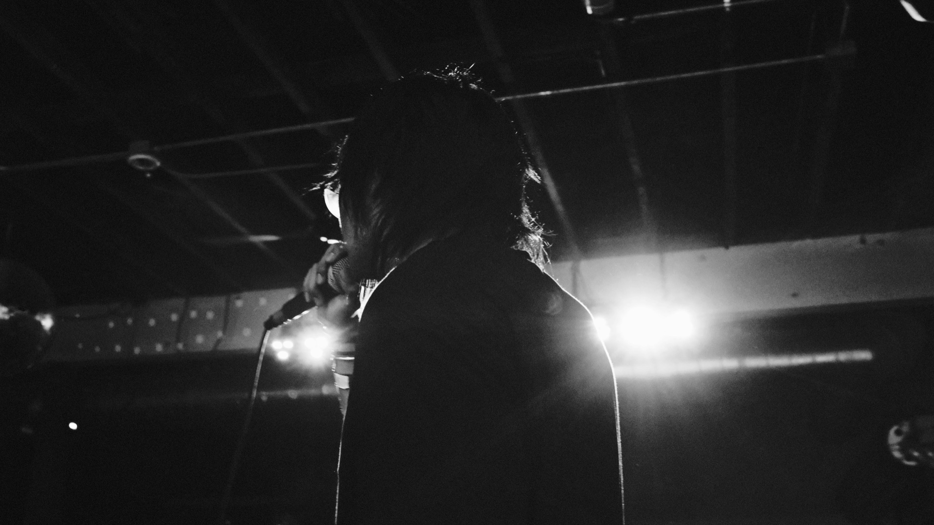 black and white shot from behind nomu facing the stage lights